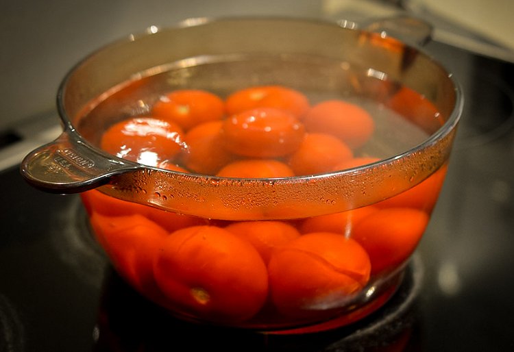 Image of Make an X on the top of each tomato. Dip...