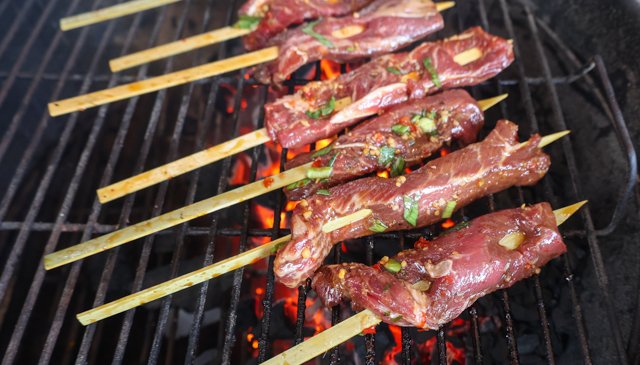 Image of Place steak skewers on the grill - meat side over...