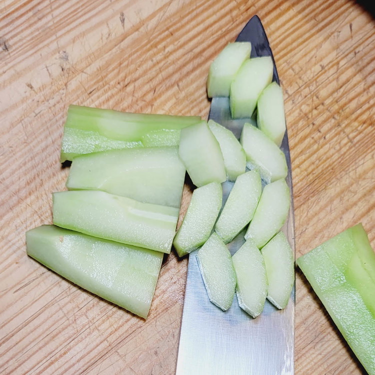 Image of Die Gurke wird der Länge nach in 4 Teile geschnitten und entkernt. Die würfelst du ebenfalls