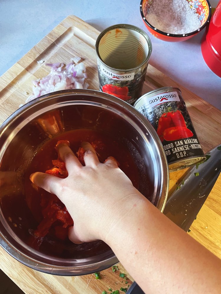 Image of Drain canned tomatoes and hand crush them in a small...