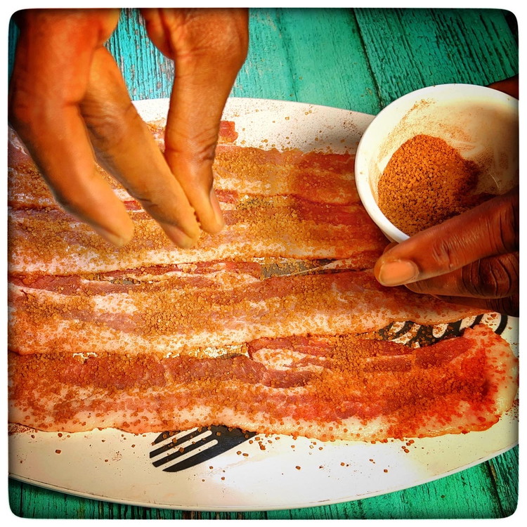 Image of Sprinkle sugar and pumpkin spice mixture on each side of the bacon to coat them sparsely then put each piece on the baking sheet