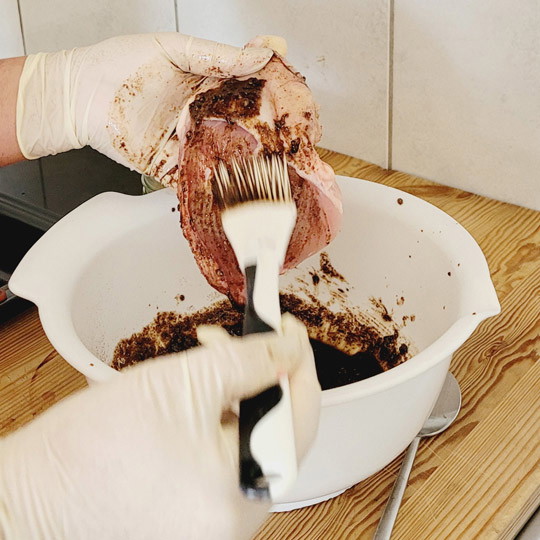 Image of Mit der Marinade bestreichst du die Hähnchenschenkel unter und auf der Haut rund herum.