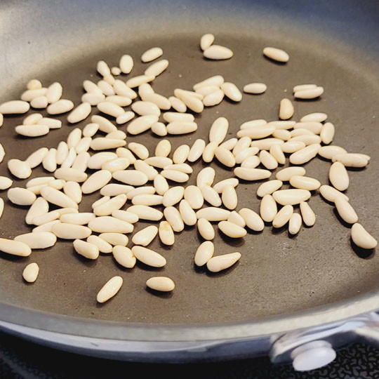 Image of Jetzt röstest du die Pinienkerne an. Ohne Öl. Lasse die Pinienkeren nicht aus den Augen. Du muss dabei bleiben, weil lange nichts passiert in der Pfanne und plötzlich nehmen die Nüsse Farbe an. Sie sind im Nu verbrannt. Sobald die...