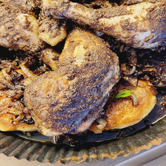 Image of Schneide das Naan quer in zwei Hälften. Lege sie mit der  Schnittfläche nach unten in die Ofenfeste Form in den Fleischsaft. Darauf streust du die Sumach Zwiebeln. Obenauf werden die Hähnchenschenkel gelegt. 