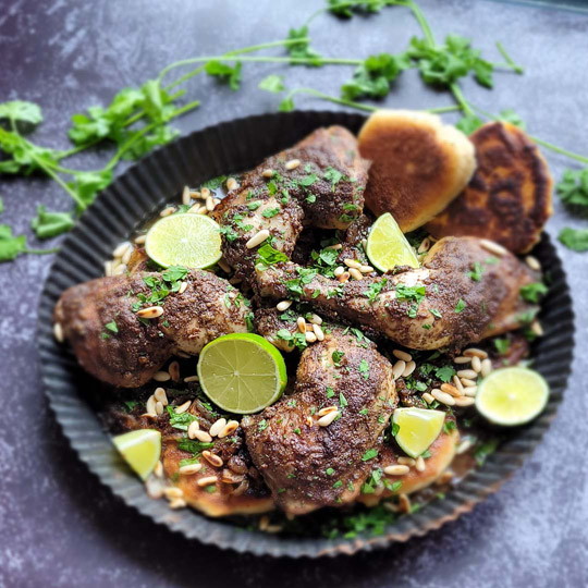 Image of Bestreue das Gericht mit dem grob gehackten Koriander und den gerösteten Pinienekernen. Das Levante Gericht Musakhan ist jetzt servierbereit.