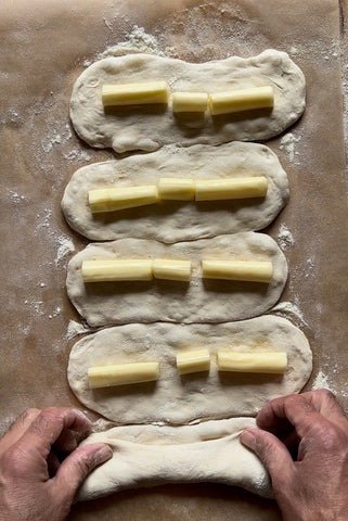 Image of Place cheese in the center of the dough. Roll over...