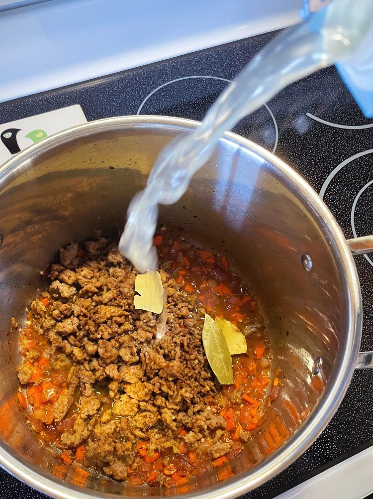 Image of Add sausage back to pot, along with chicken broth and...
