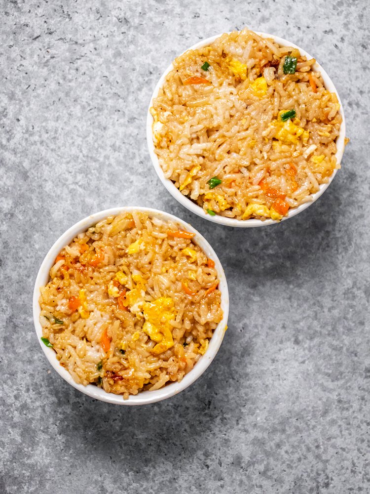 Image of Pack fried rice into 2 small bowls or ramekins. Set...