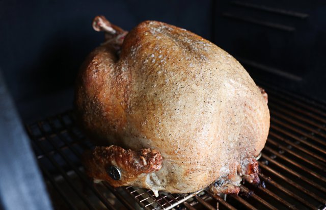 Image of Place the turkey on the smoker and baste with melted...
