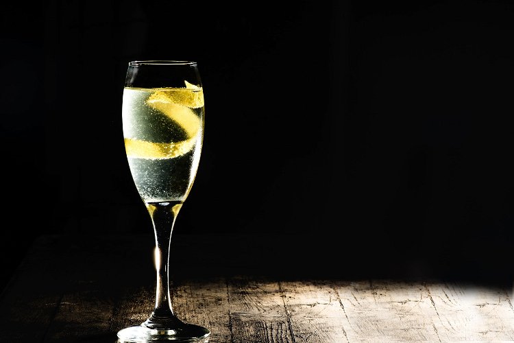 Image of Garnieren Sie den Drink, indem Sie die Zitronenschale um Ihren...
