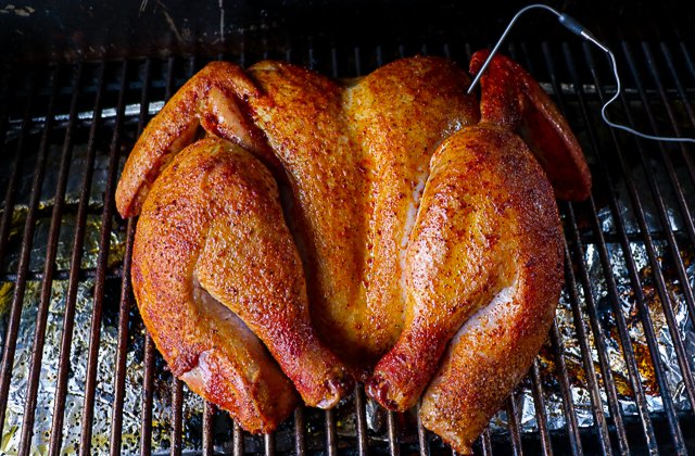 Image of Place turkey skin side up on the smoker. Tuck the...