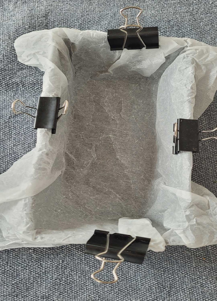 Image of In der mit Backpapier ausgelegten Form legst du die eingewickelte Wurst mit der Naht nach unten in die Cakeform und lässt die Teigwurst nochmals 15 Minuten ruhen. Den Backofen stellst du auch 200 Grad O/U Hitze ein.