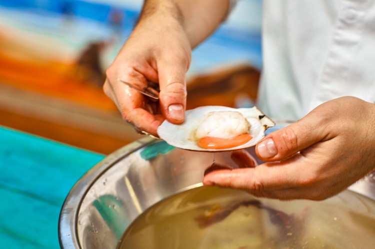 Image of Dans un bol d'eau froide, lavez la coquilles avec la noix de pétoncle afin d'enlever les impuretés. Réservez ensuite sur glace.
