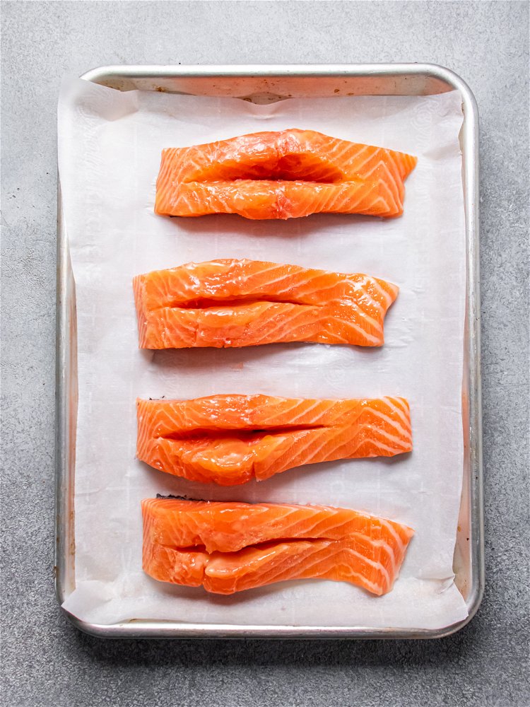 Image of Blot excess moisture from salmon with paper towel. Slice salmon...