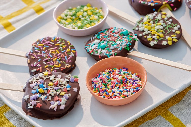 Image of Create Your Chocolate Covered Apple Lollipop: Holding the popsicle stick, spoon...