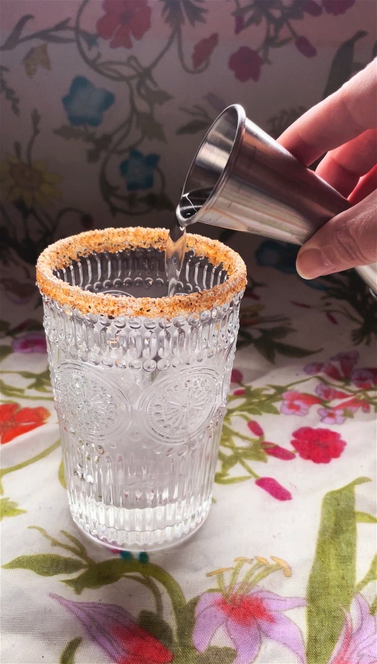 Image of Rub slice of lemon around rim of glass and dip...