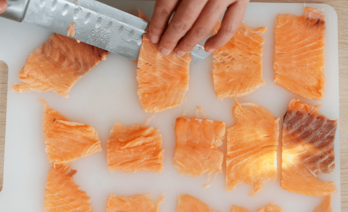 Image of Next, slice the salmon into thin strips that are approximately...