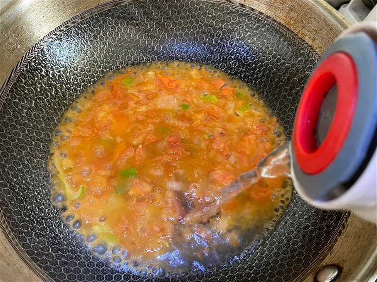 Image of Quando surgir o caldo de tomate, colocar água até metade...