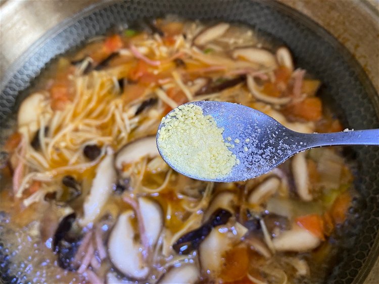 Image of Temperar a sopa com essência de galinha, sal e pimenta...