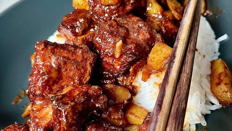BBQ Pork Adobo in a black dish with rice and chopsticks