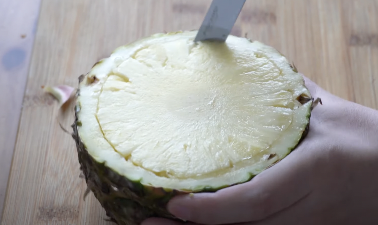 Image of Preparar um ananás, cortar ao meio e retira a polpa.