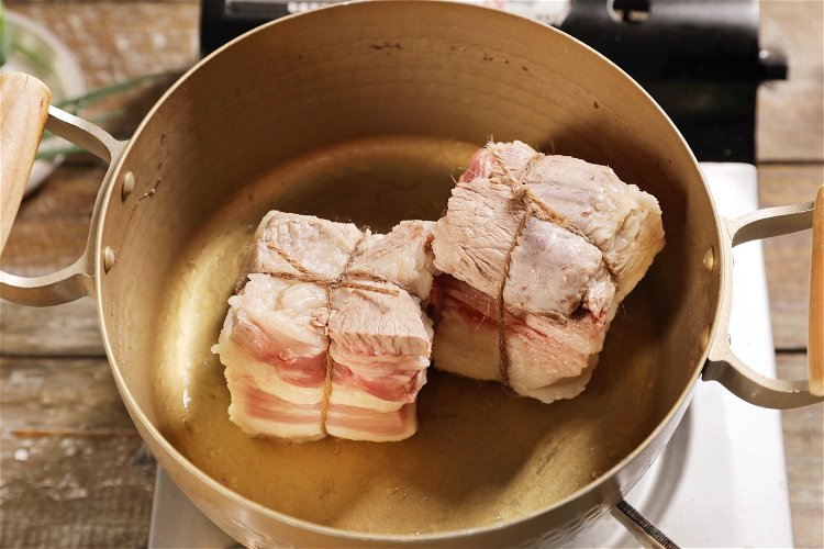 Image of Carne de porco frita amarrada em cruz com fio de...