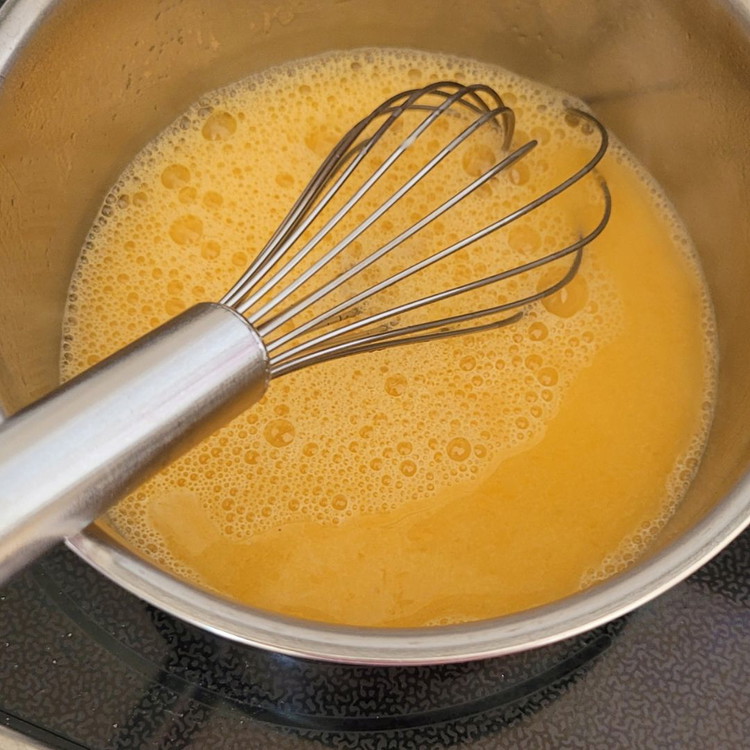 Image of In einem Topf 50 g Zucker mit dem Rest des Mandarinensaft aufkochen. Der Zucker sollte sich aufgelöst haben. Unter ständigem rühren die aufgelöste Stärke hinzufügen und zu einer dicklichen Creme einkochen