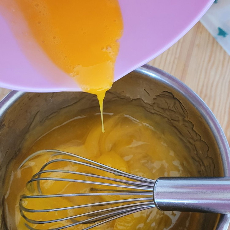 Image of in die ausgekühlte Mandarinencreme die beiden Eigelbe einrühren