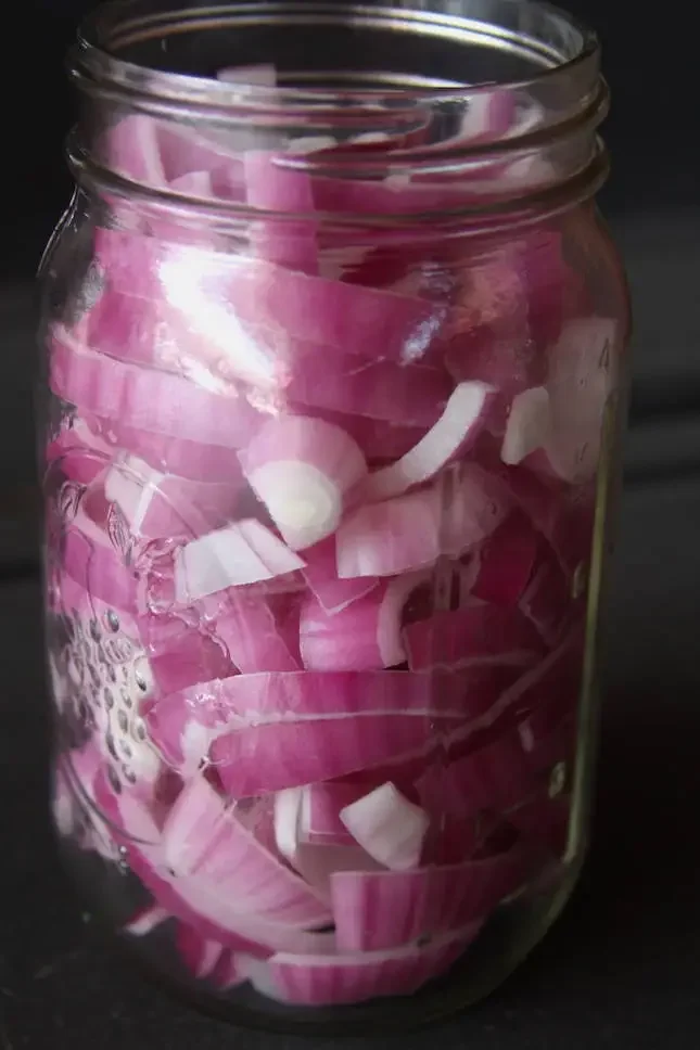 Image of Fill a quart sized mason jar with the sliced red...