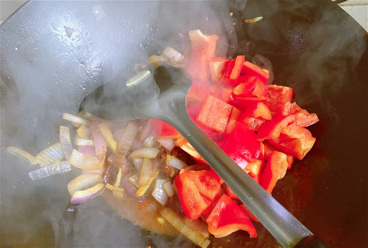 Image of Adicionar os pimentos coloridos e continuar a saltear.