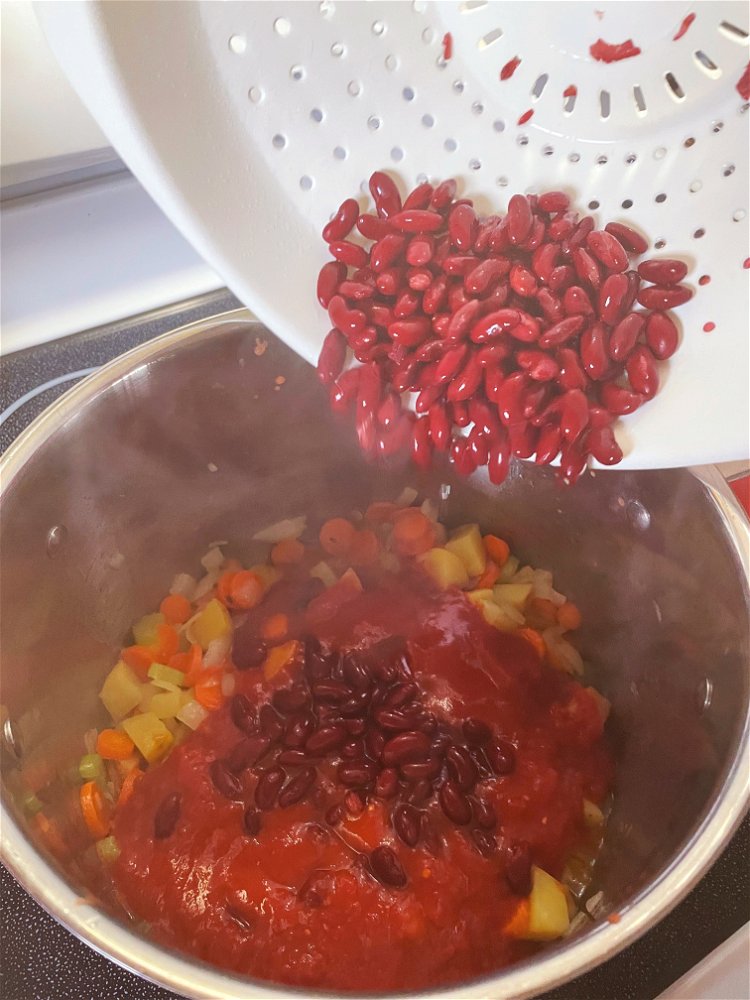 Image of Add tomatoes and beans to your pot.