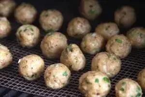 Image of Place meatballs on top of FrogMats on the grates of the smoker...
