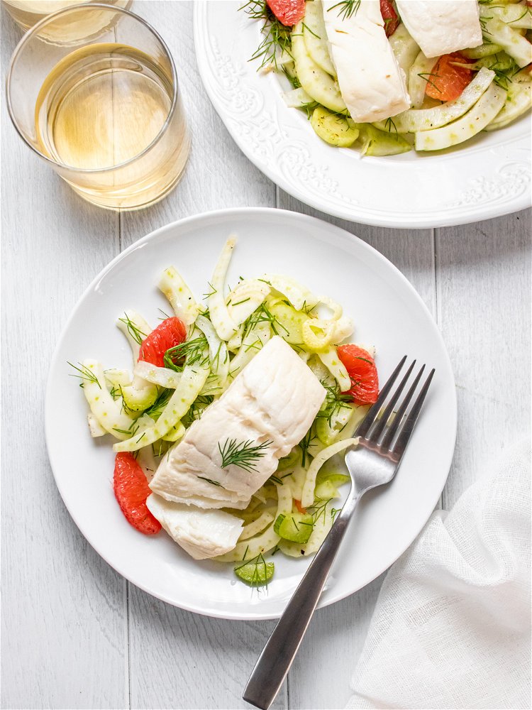 Image of Top salad with poached halibut and garnish with fresh dill....