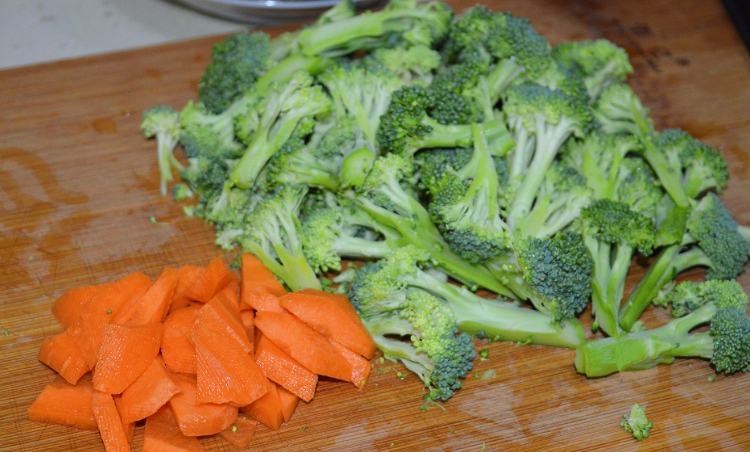 Image of Lavar os brócolos e as cenouras e cortá-los em pedaços.