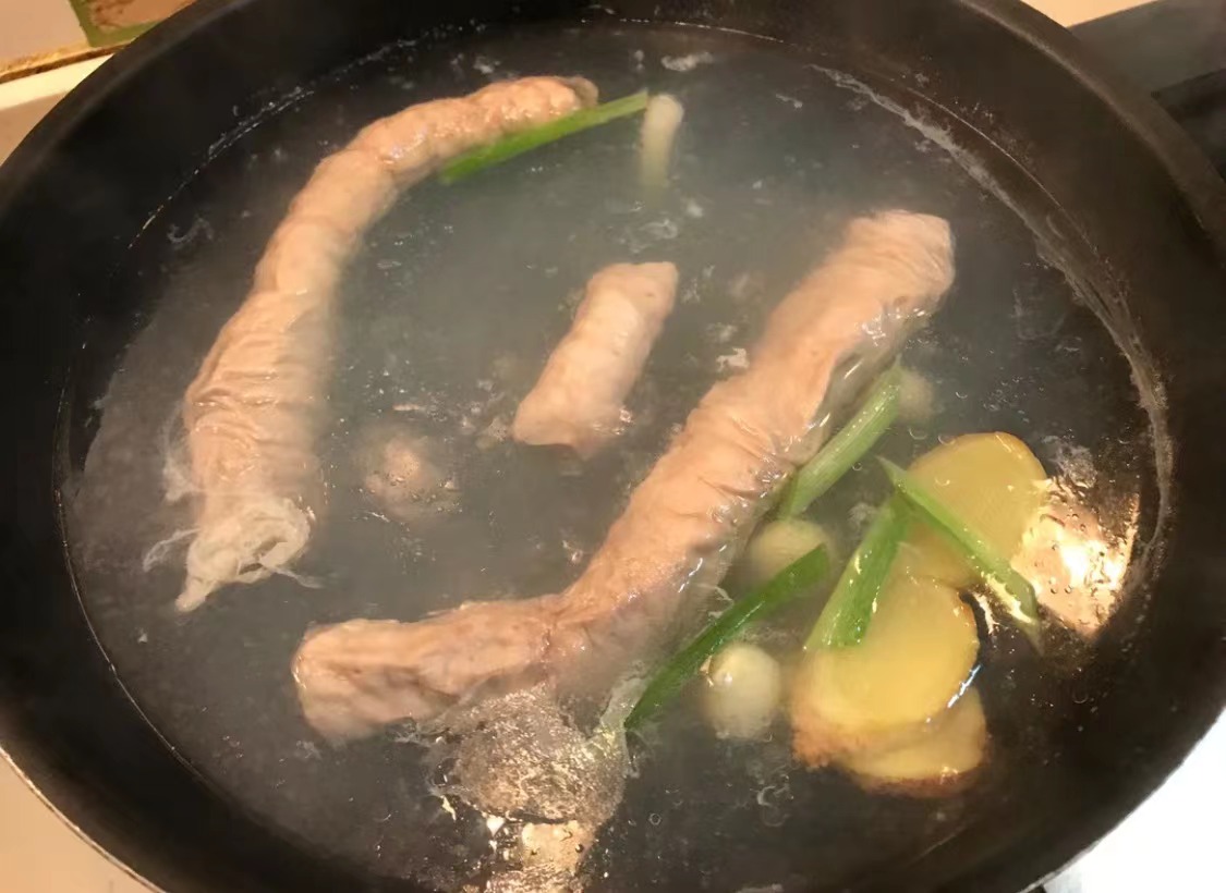 Image of Lave a tripa do porco, coloque-o no wok em água...