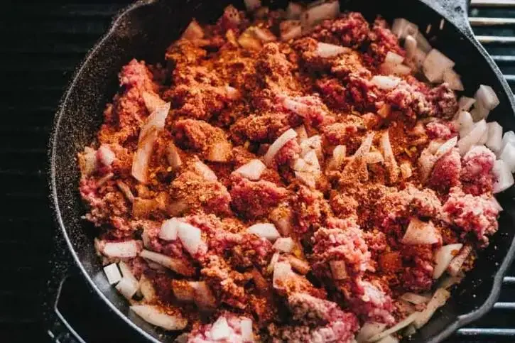 Image of Ground beef, onions and seasoning in the skillet.