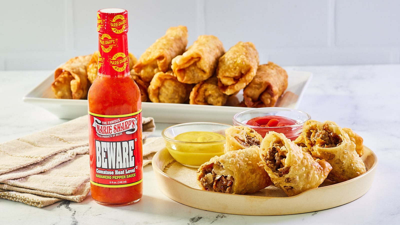 Image of Cheeseburger Egg Rolls with Marie Sharp’s Beware Comatose Level Habanero Pepper Sauce