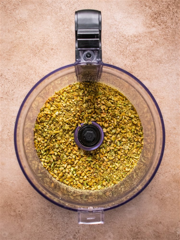 Image of Add pistachios, thyme, garlic powder and salt to a food...
