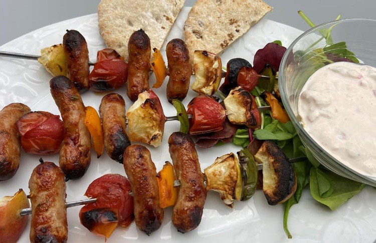 Image of Serve kebabs with the tomato and sour cream dip,  salad leaves and pitta breads.