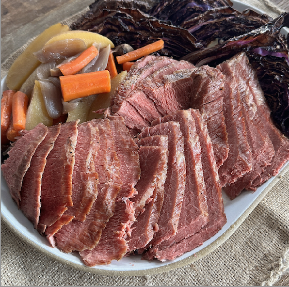 Image of Remove the brisket and allow it to rest for 15 minutes before carving it into thin slices against the grain.