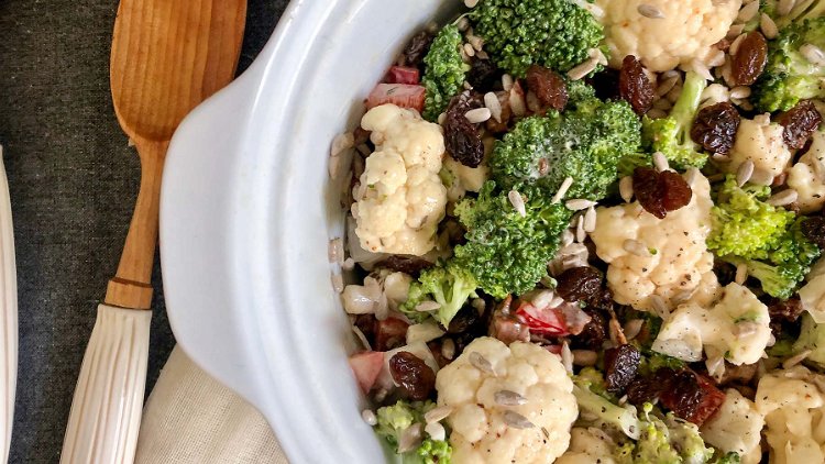 Image of Combine broccoli, cauliflower, bacon, raisins, and sunflower seeds with dressing.