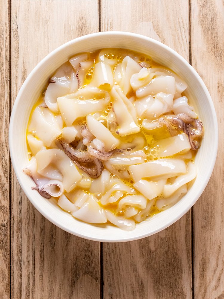Image of Add beaten egg to calamari and stir to coat. 