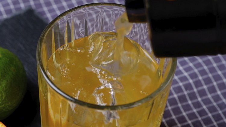 Image of Zum Schluss das Getränk mit einer Orangenscheibe in einem Cocktailglas...