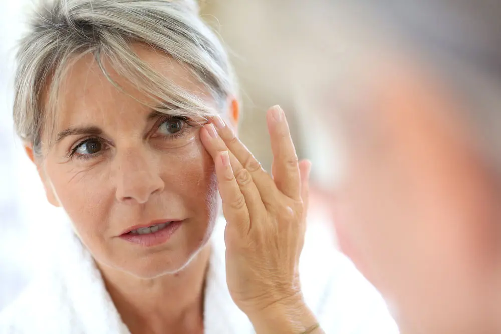 woman applying honey under-eye mask
