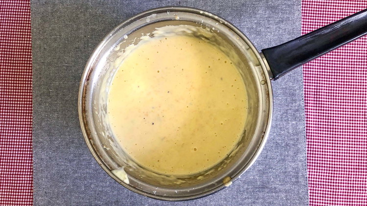 Image of In a large sauce pot, melt butter on medium heat. Then add milk, flour, salt, and pepper. Whisk together carefully and keep the mixture from forming lumps. When the mixture starts to boil, add chunks of cheese and cook until...