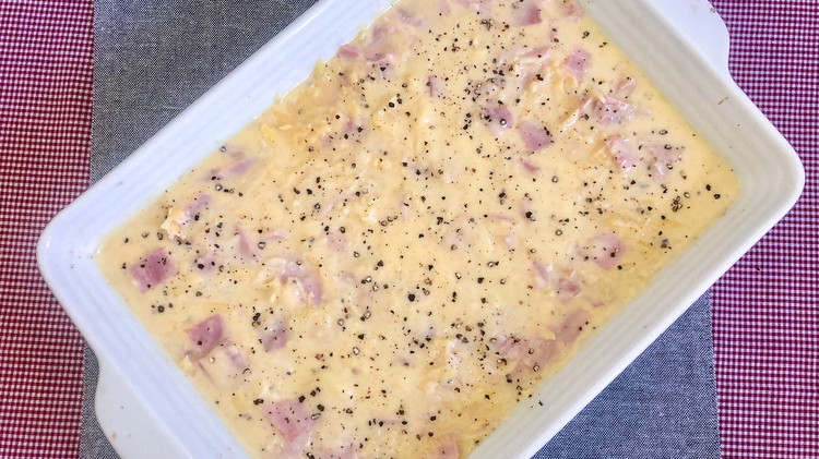 Image of Pour the rest of the cheese sauce onto greased 9x13 casserole pan. Then add the potato and ham mixture. Mix well if needed.