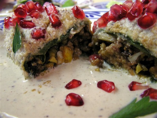 Image of Chiles en nogada (stuffed poblano peppers topped with walnut cream sauce and pomegranate seeds)