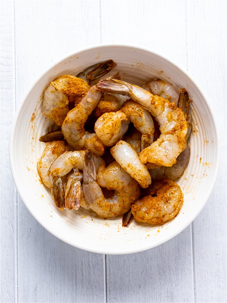 Image of Stir together shrimp and 1 tablespoon of curry powder to...