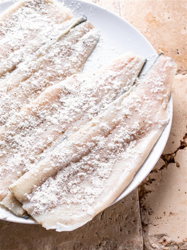 Image of Season flesh side of trout with flour mixture. Set aside.