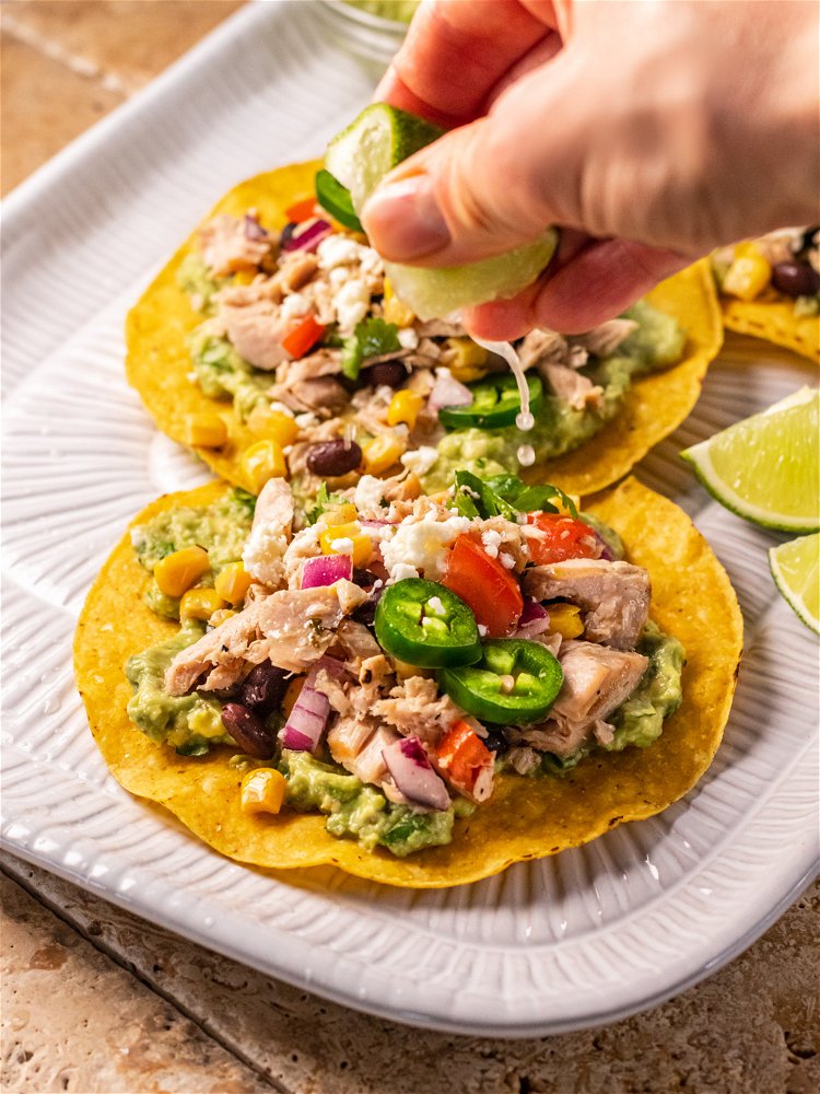 Image of Spread 2 tablespoons of guacamole on tostadas and top with...